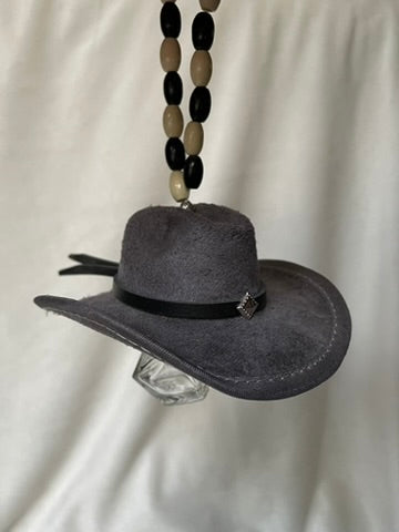 Gray miniature cowboy hat with a black band hanging from a beaded elastic loop on a white background